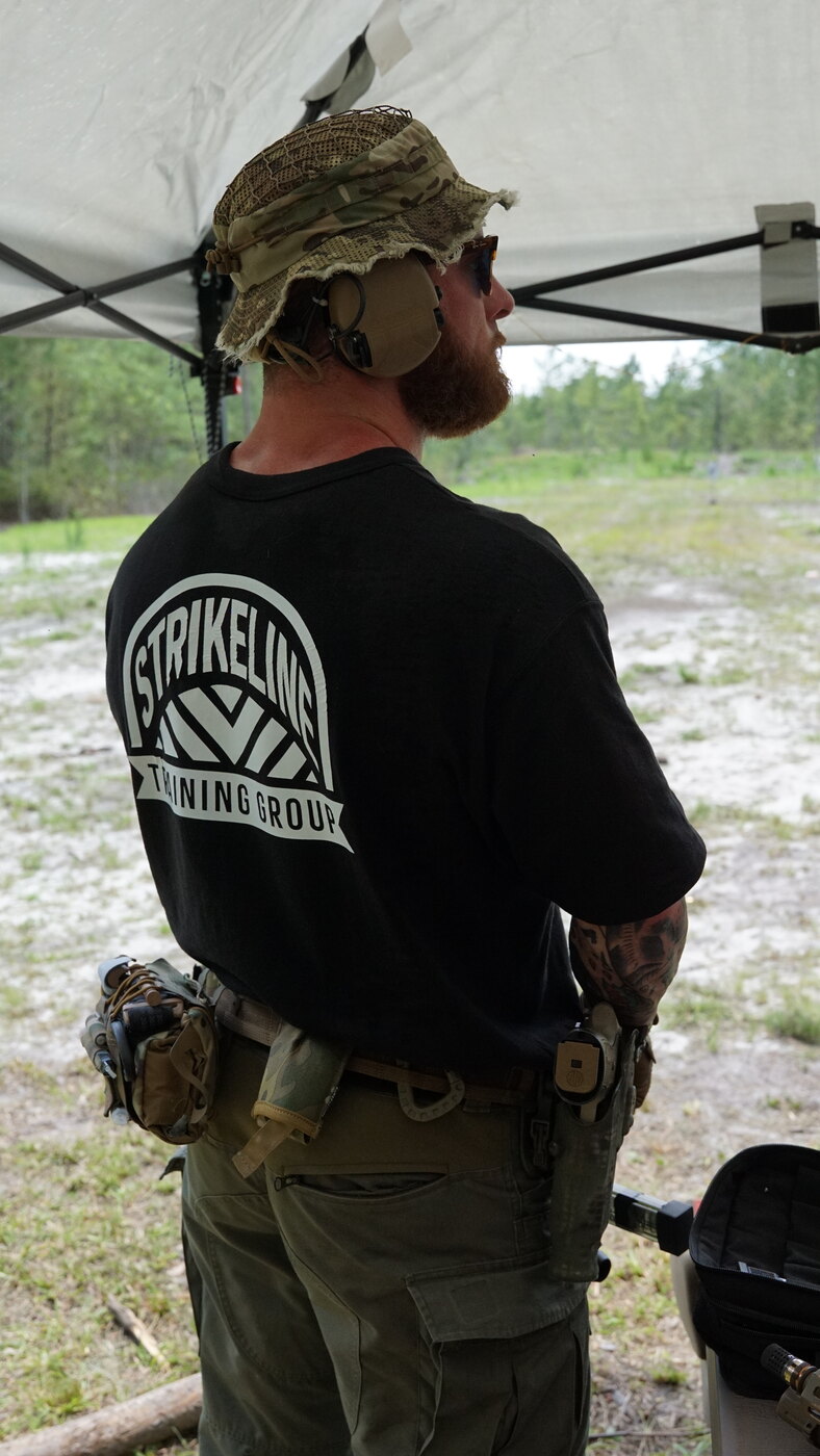 Tactical athlete in Strikeline shirt and kit at an outdoor range